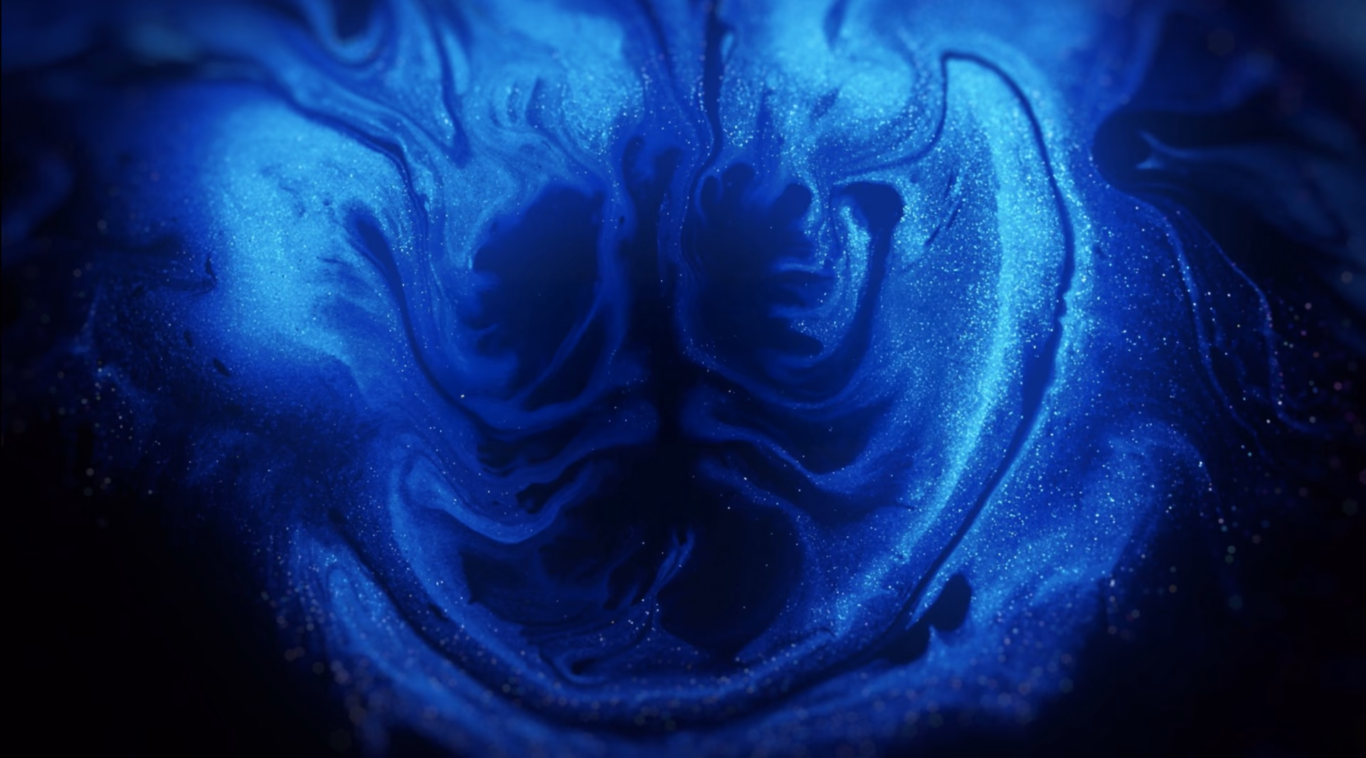Volutes d'encre bleue aux reflets lumineux, illustrant la richesse des couleurs et des contrastes